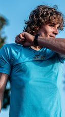 Runner training on outdoor track in warm weather wearing SA1NT LAYERS compression gear