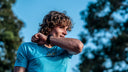 Runner outdoors checking a watch mid session in SA1NT LAYERS running kit