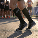 Runner wearing SA1NT LAYERS Compression Race Socks Black Silver at a marathon start line