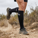 Trail runner wearing SA1NT LAYERS Compression Race Socks Black Silver