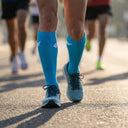 Runner wearing SA1NT LAYERS Compression Race Socks Bright Blue White at a race start line