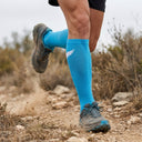 Trail runner wearing SA1NT LAYERS Compression Race Socks Bright Blue White