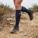 Trail runner wearing SA1NT LAYERS Compression Race Socks Charcoal Bright Blue