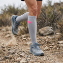 Trail runner wearing SA1NT LAYERS Compression Race Socks Light Grey Hot Pink